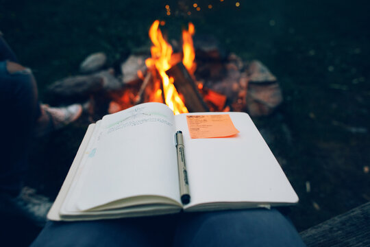 Campfire stories. Drawing and taking notes next to a campfire during travels. Storytelling