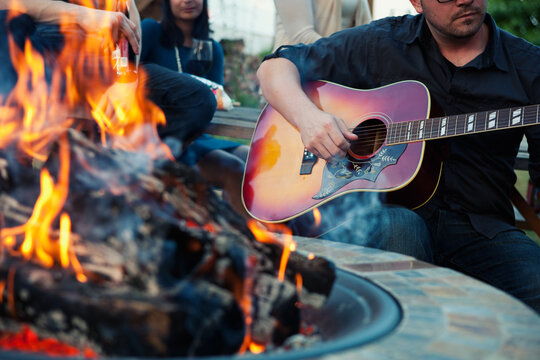Party: Man Playing Guitar By Fire Pit