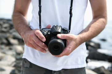 Man at beach uses a digital SLR camera