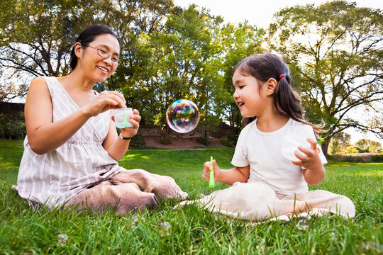 Asian mother and daughter with soap bubbles