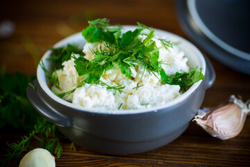 salted homemade cottage cheese with garlic and herbs in a bowl