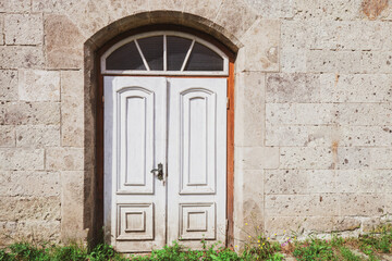 Fototapeta na wymiar Old abandoned white wooden door in house at city street