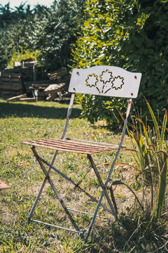 Vintage Metal Folding Chair With Ornament In A Garden