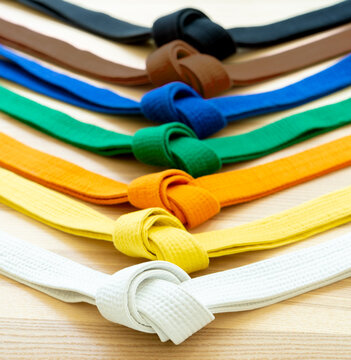 Martial arts colored belts on a wood background.