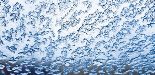 View from inside of automobile with windshield covered in frozen snowflakes. Winter driving conditions.