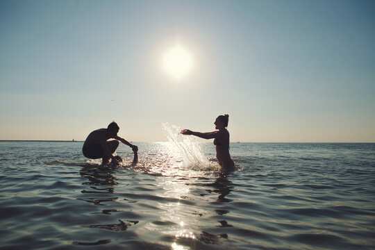 Friends having fun in the ocean on a sunny day.