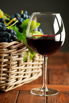 Red wine glass and wicker basket of grapes