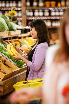 Market: Woman Choosing Bananas In Market