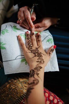Woman drawing a henna tattoo on a hand