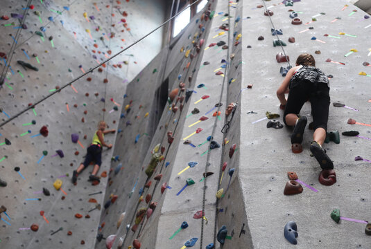 Two young girls determined to get to the top of the rock wall