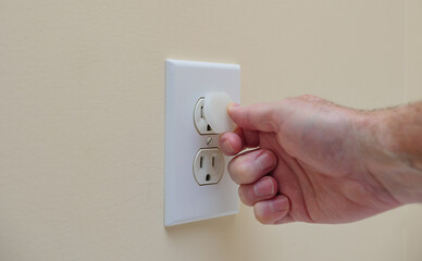 Installing electrical outlet electricity safety cover to prevent child electrocution. Child...