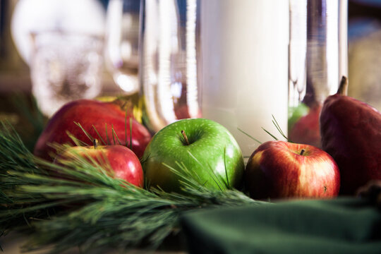 Apples, pears and pine needles make up a table centerpiece.