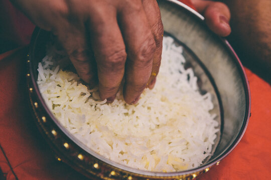 Hand picking rice from a bowl