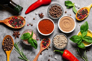 Assortment of spices, herbs and salt on dark marble table top view. Healthy food concept.