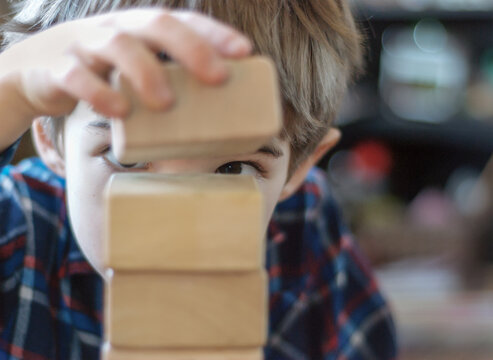 Boy stacks blocks with careful precision