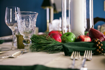 Autumn fruit adorn a centerpiece on a formally set Thanksgiving