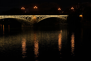 Fototapeta na wymiar triana bridge at night with lights sevilla guadalviquir river