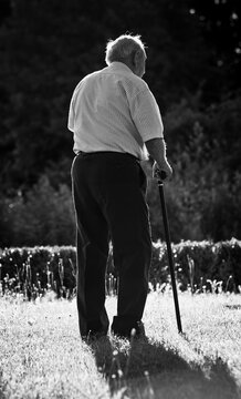 Senior Man With Stick Walking Away