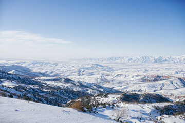 Fototapeta na wymiar Tien Shan mountains covered with snow in Uzbekistan on a clear day. Beldersay ski resort