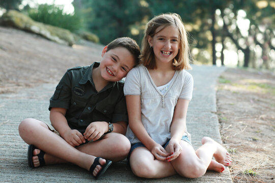 Young boy and girl leaning on each other and laughing