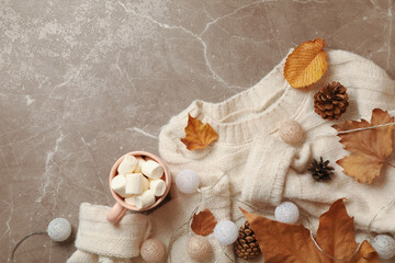 Autumn concept with sweater and coffee on gray background