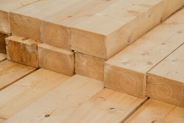 Piled wooden beams. Closeup big wooden boards. Stacked wooden beams of square section for house construction