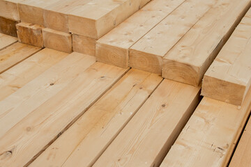 Piled wooden beams. Closeup big wooden boards. Stacked wooden beams of square section for house construction