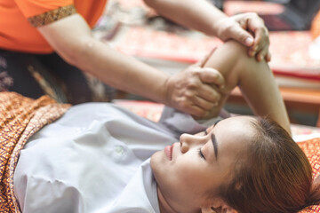 Original thai medical massage. Thai massage and spa for healing and relaxation. Young woman getting traditional thai stretching massage.