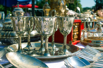 Antiques on flea market or festival - vintage silver shot glasses and other vintage things. Collectibles memorabilia or garage sale concept