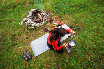 Girl Camping with woodfire and boling water on stove