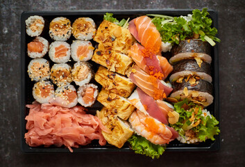 Close up of Various sushi set in black plastic delivery box. Top view