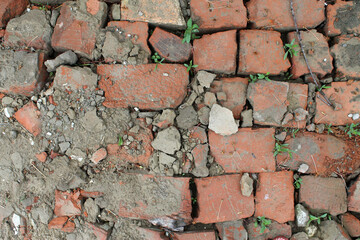 bricklaying from broken red brick with sprouted grass