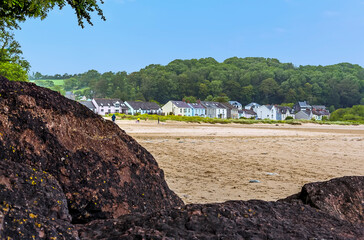 A view across the beach back towards the village of Llansteffan, Wales in the summertime