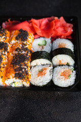 sushi rolls fish salmon, vegetables, ginger wasabi rice and nori on the table serving portion size top view place copy space for text