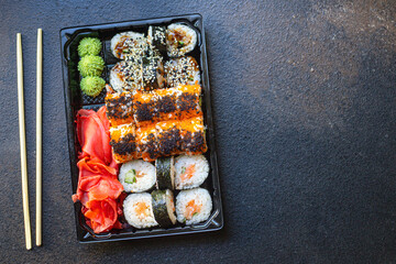 sushi rolls fish salmon, vegetables, ginger wasabi rice and nori on the table serving portion size top view place copy space for text