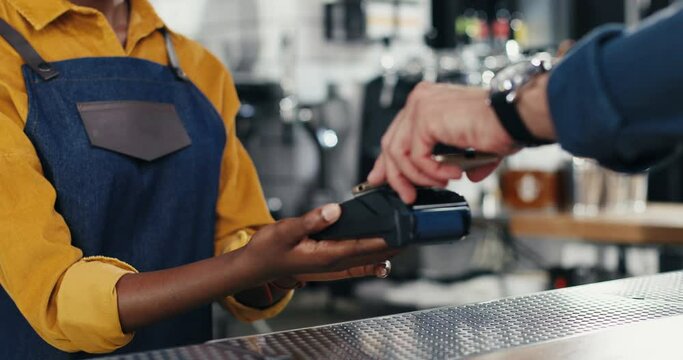 Close up hands of multiethnic bartender woman and client man. Caucasian male paying with paypass, credit card. Mixed-races. Passing payment at counter. Pay for drink or food. African American waitress