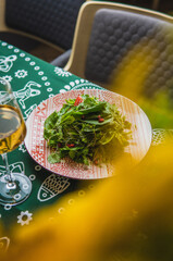 Georgian salad with glass of white wine with blur in restaurant