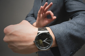 A wrist watch on the businessman hand close up.