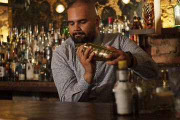 Primer plano de Barman Cantinero mexicano profesional preparando un cóctel alcohólico para los clientes en el bar o discoteca