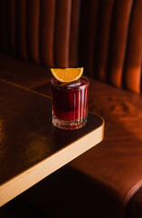 Cocktail with a slice of orange on the table in pub
