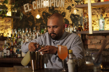 Barman Cantinero mexicano profesional preparando un cóctel alcohólico para los clientes en el bar o discoteca