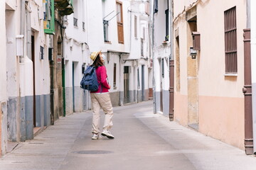 Fototapeta na wymiar Woman sightseeing walking down a street