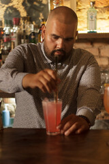 Barman Cantinero mexicano profesional preparando un cóctel alcohólico para los clientes en el bar o discoteca