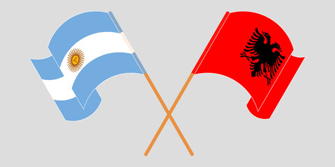 Crossed and waving flags of Albania and Argentina