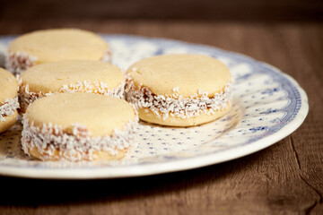 Delicious Argentinian cookies cornflow alfajores with cream dulce de leche close-up isolated. White vanilla macaroons on white background. French delicate dessert for Breakfast.