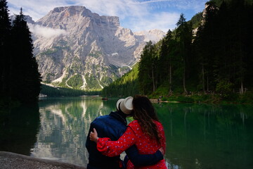 Young couple watching the clear water of Lago di Braies. Dolomites, Unesco, Val Pusteria, Sudtirol,...