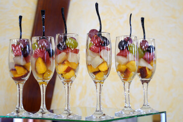 dessert of sliced ​​fresh fruits in wine glasses on a buffet table
