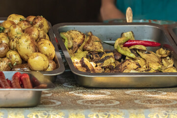 Culinary buffet with takeaway healthy food - meat, pepper, spices, grilled vegetables. Fish and meat on the street, food market, festival, event. Kitchen in the open air.
