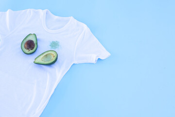 dirty avocado stain on white t-shirt.Isolated on blue background