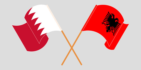 Crossed and waving flags of Albania and Bahrain